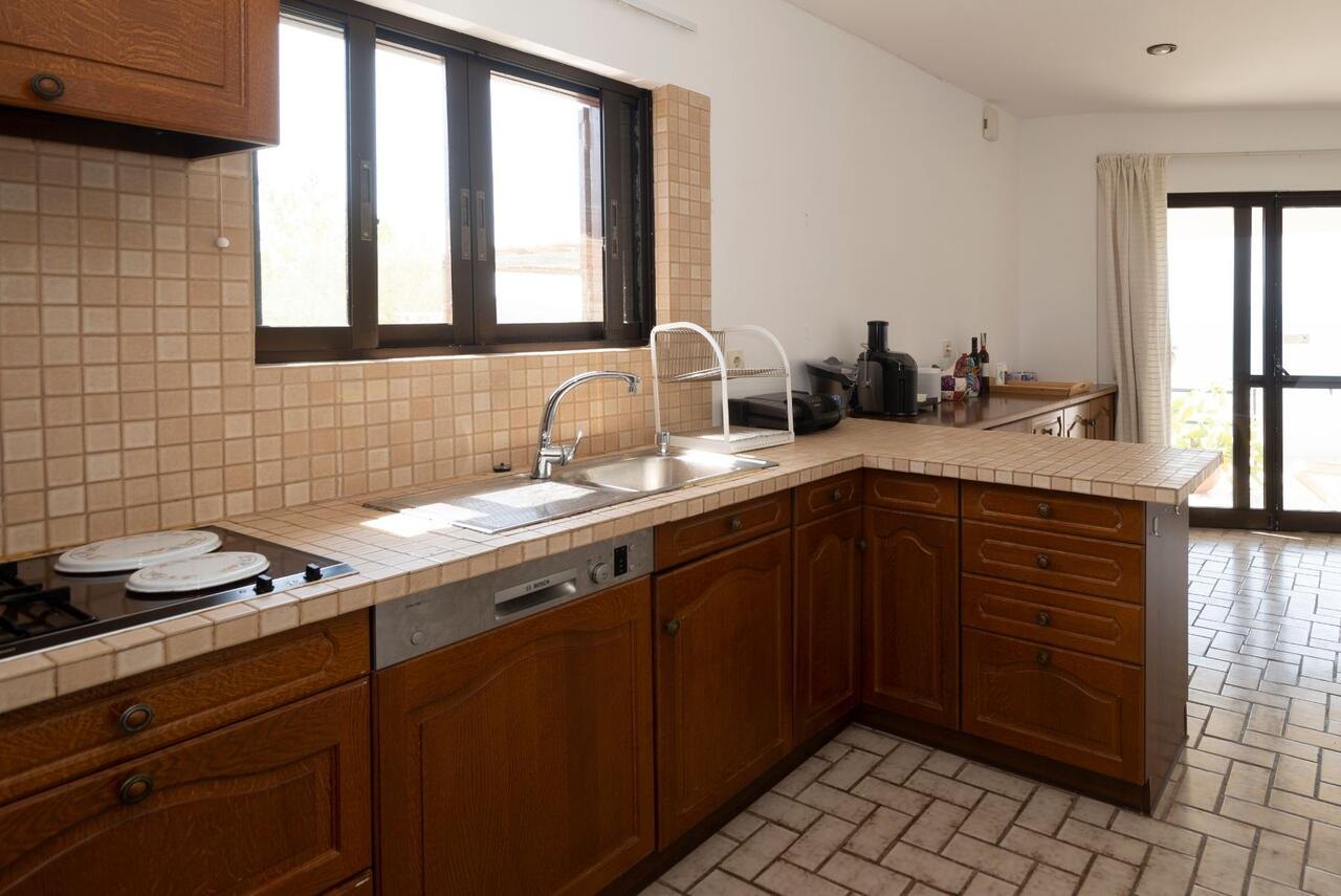 Küche mit Holzfronten und heller Arbeitsplatte